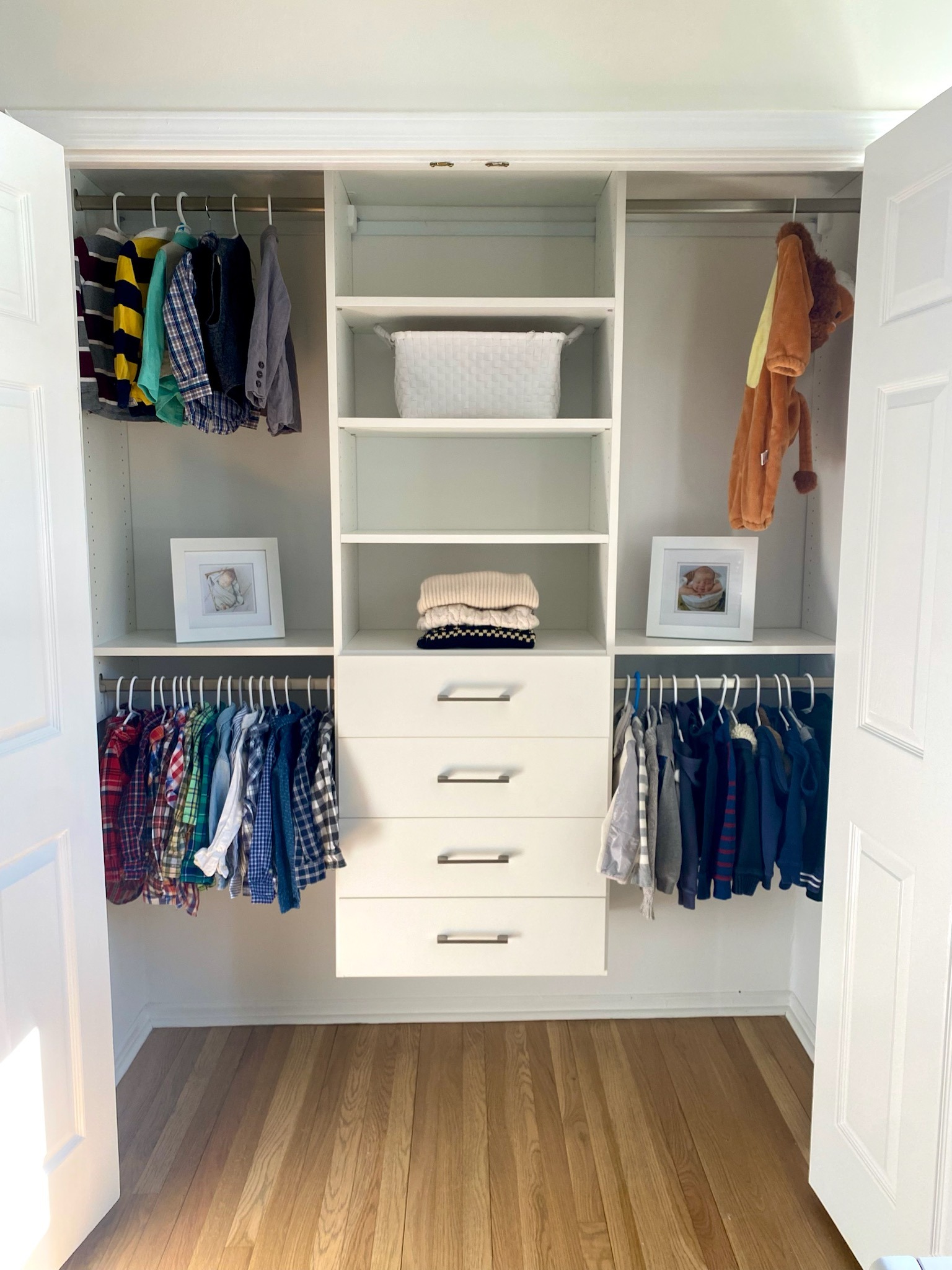Boys reach-in closet with organized sports equipment, clothes, and efficient white storage systems