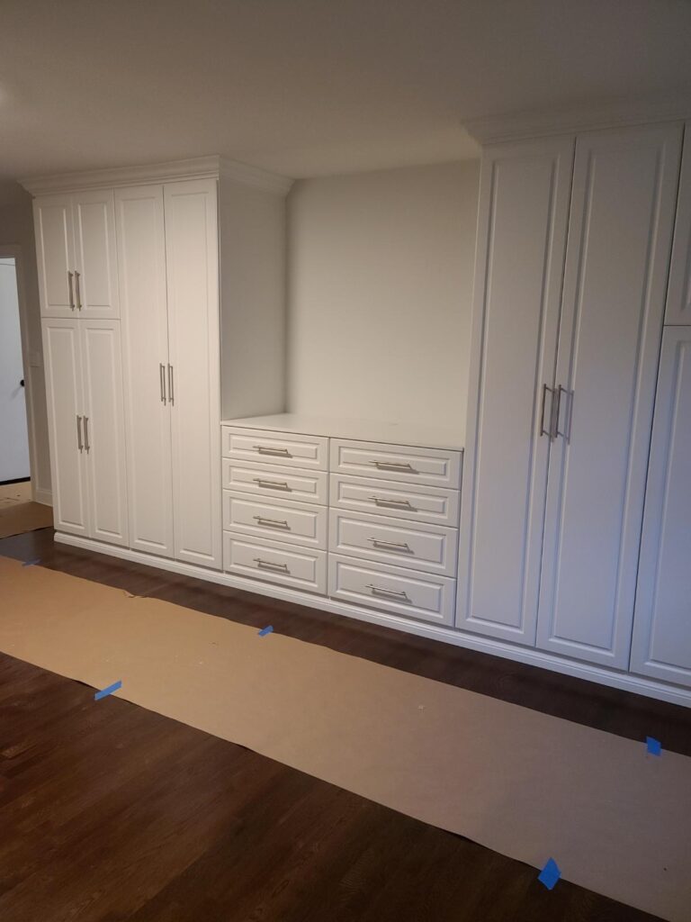 Empty walk-in closet with basic white shelving system and hanging rods for simple organization