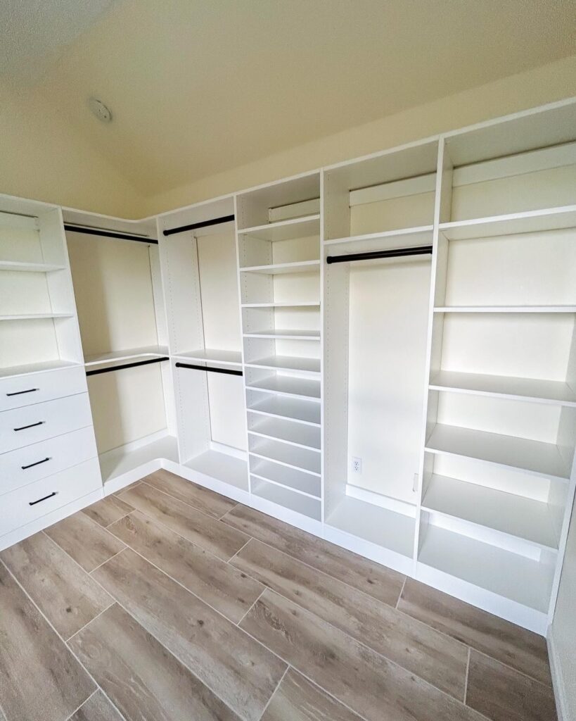 Empty white walk-in closet displaying complete organizational system with multiple hanging heights and drawer units