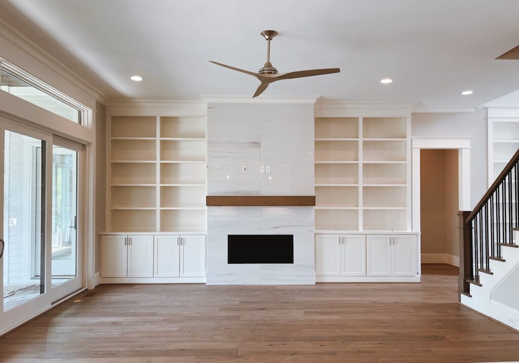 Custom white built-in entertainment center with fireplace surround and floor-to-ceiling storage cabinets