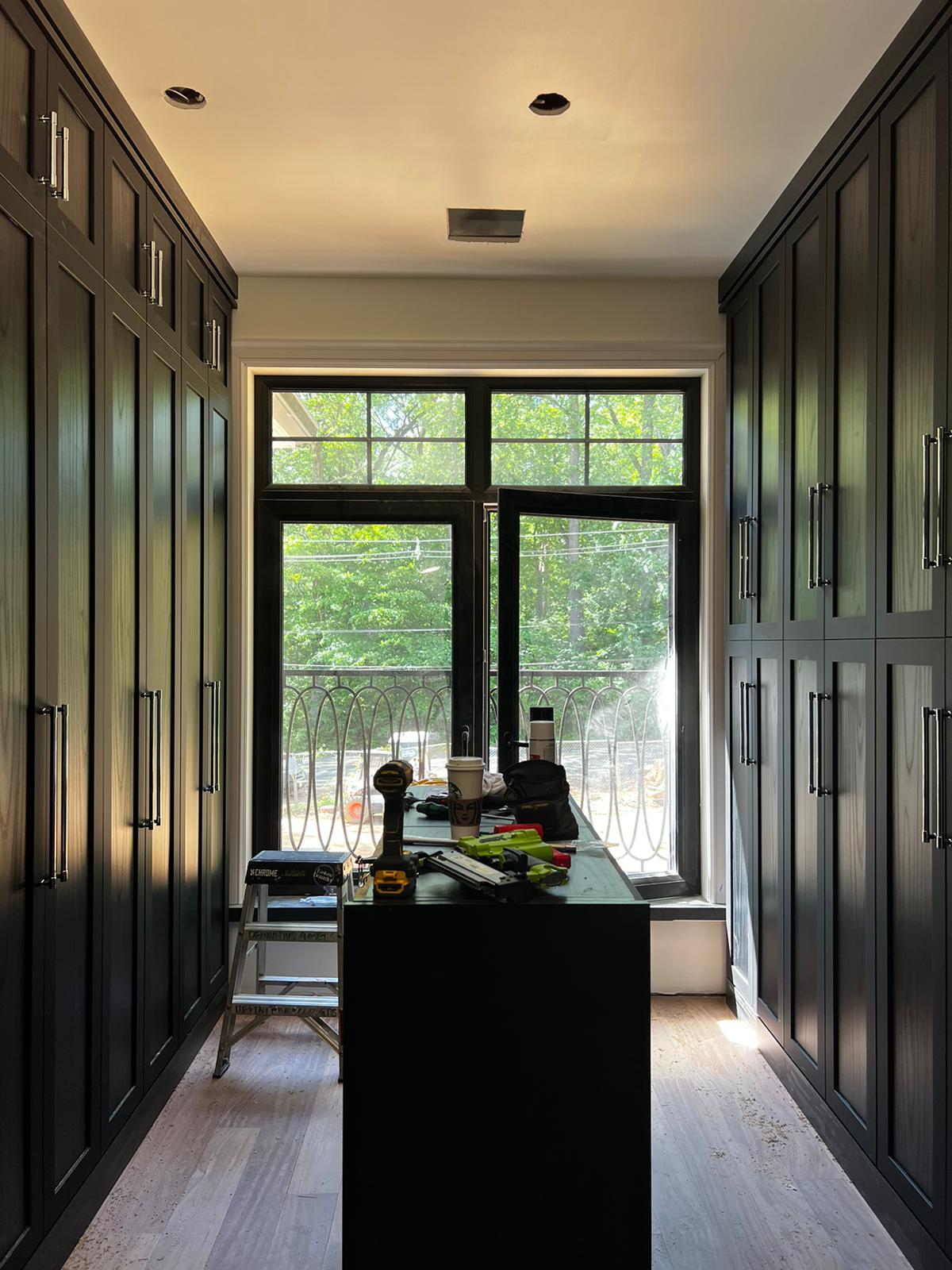 Luxury mudroom and office area with dark wood storage systems and built-in workspace