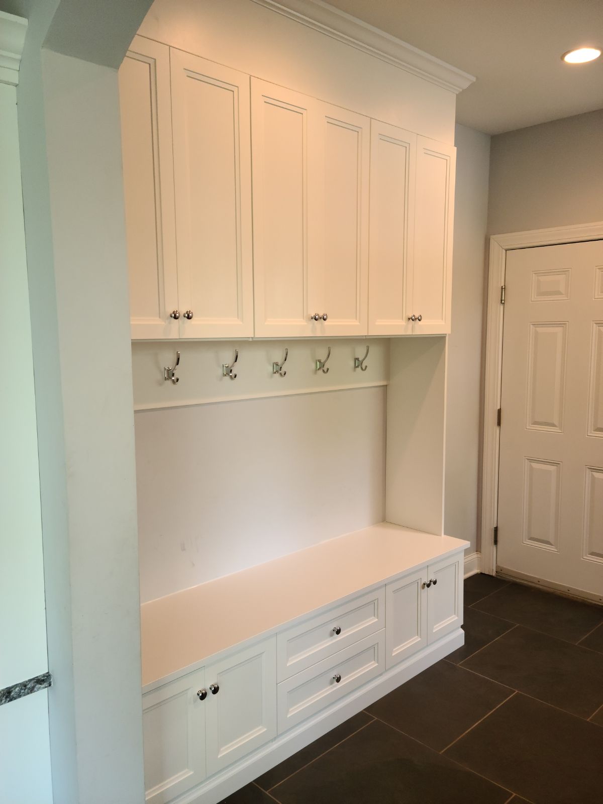 Mudroom with white cabinet storage, coat hooks, and alternative entryway organization