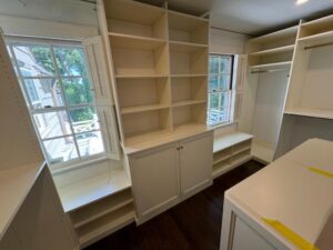 Organized walk-in closet with white storage systems and efficient space utilization
