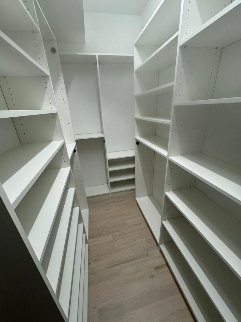 White pantry with floor-to-ceiling shelving and organized food storage solutions