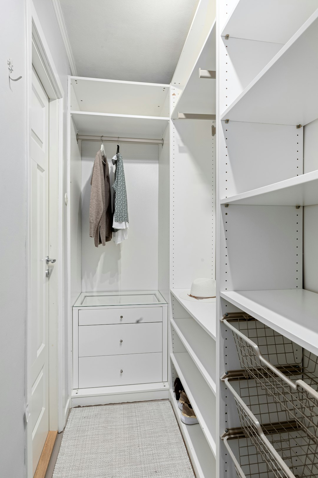 Small walk-in closet design with efficient white storage systems and space optimization