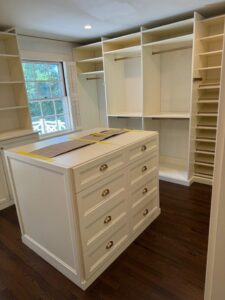 Walk-in closet featuring center island, organized hanging sections, and comprehensive shelving systems for maximum storage capacity