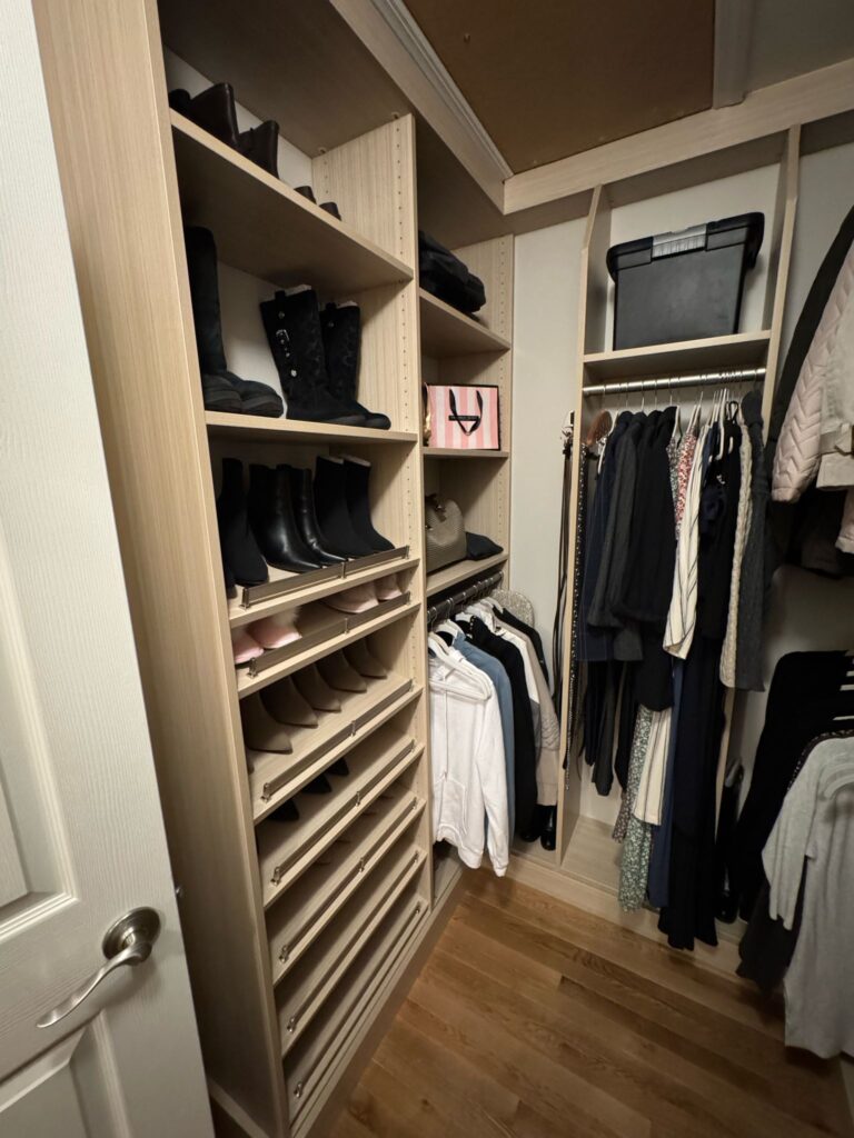 Walk-in closet featuring distinctive slanted shoe shelves and boot storage organization