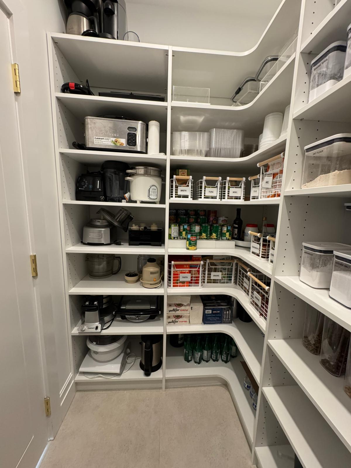 Walk-in pantry with small appliances, food storage, and lived-in organization