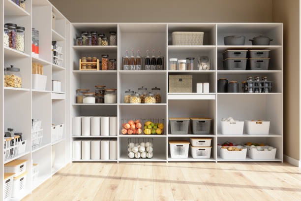Organized walk-in pantry with white shelving and labeled storage containers for kitchen organization