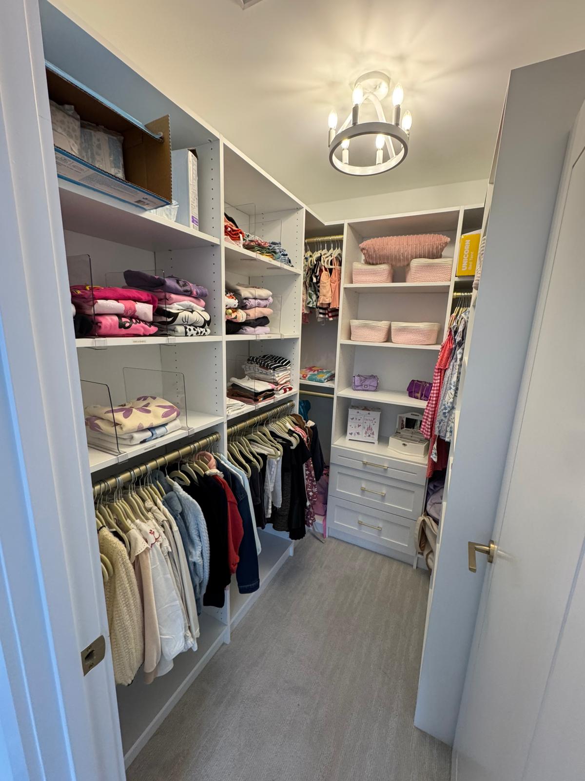 Women's walk-in closet with lived-in organization, extensive wardrobe, and daily-use functionality